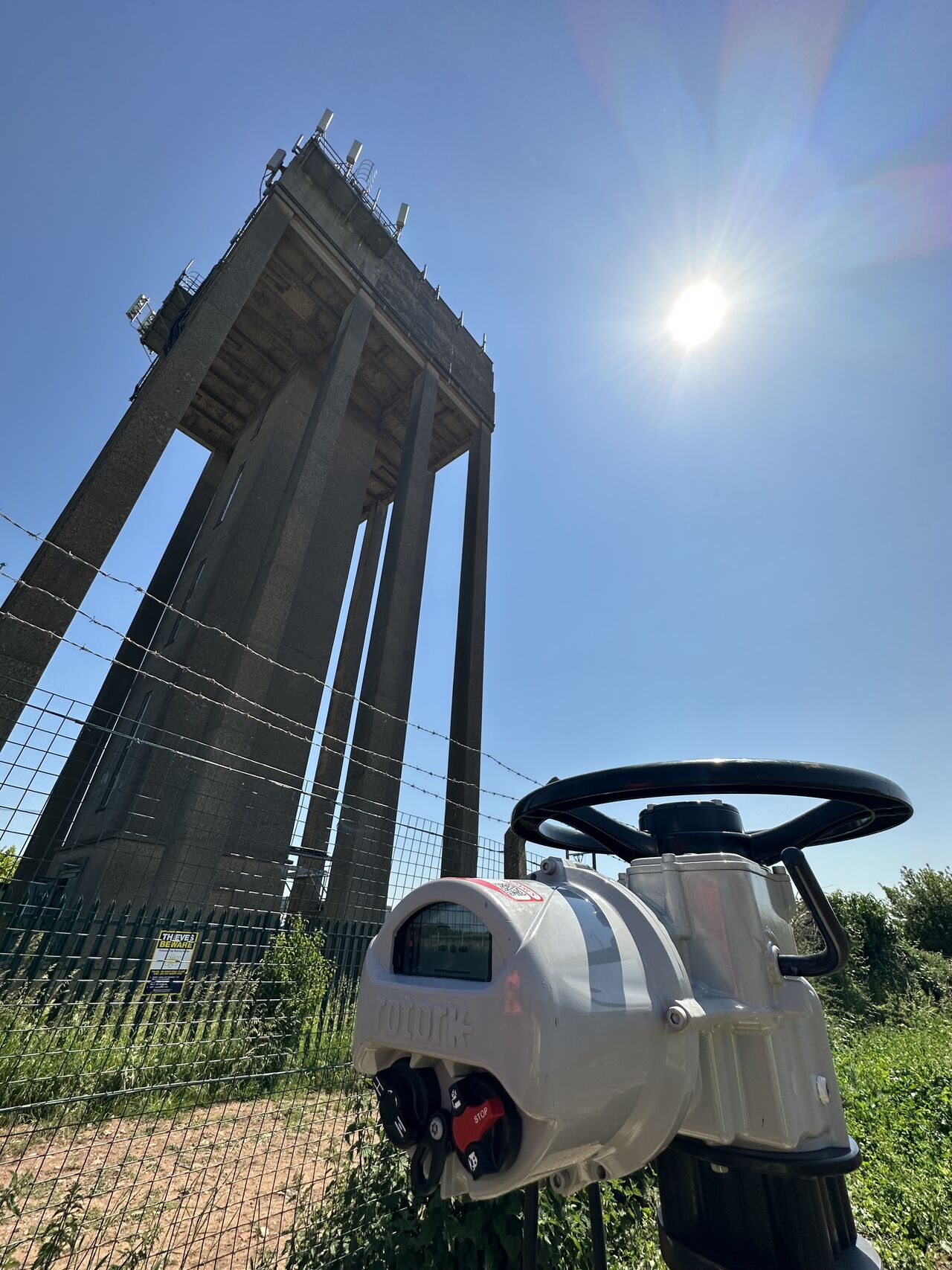 Industrial actuator installed at a UK water site under bright sunlight, photographed during routine servicing